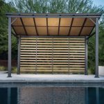 Outdoor hardtop gazebo with slated back wall for privacy and all-season durability.