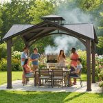 Black square hardtop gazebo with aluminum and steel frame in backyard.